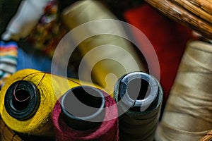 Closeup shot of colorful yarn rolls in a woven basket