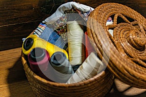 Closeup shot of colorful yarn rolls in a woven basket