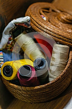 Closeup shot of colorful yarn rolls in a woven basket