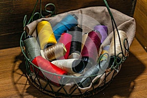 Closeup shot of colorful yarn rolls in a woven basket