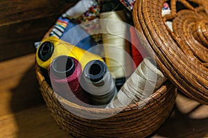 Closeup shot of colorful yarn rolls in a woven basket