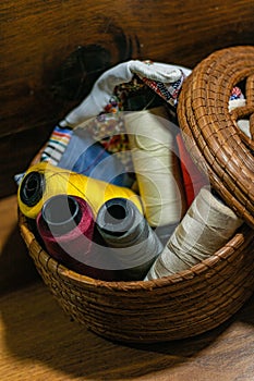 Closeup shot of colorful yarn rolls in a woven basket