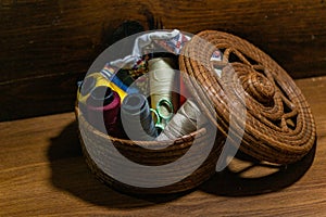 Closeup shot of colorful yarn rolls in a woven basket