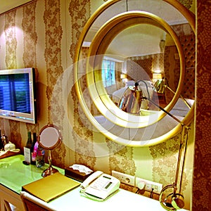 Closeup shot of a console mirror in an illuminated hotel room
