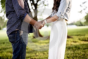 Closeup shot of a couple holding hands with a blurred background