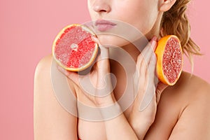 Close up shot cropped blonde half naked woman 20s perfect skin nude make up hold in hand grapefruit isolated on pastel