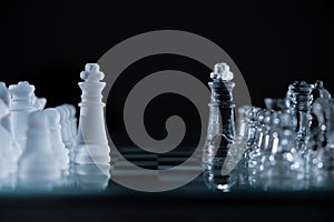 Closeup shot of crystal chess pieces on a glass board on black background