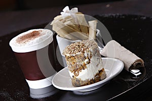 Closeup shot of the cup of latte coffee with a delicious pastry cake