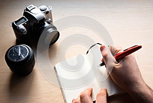 Closeup shot of a cup of tee and a camera on a wooden table