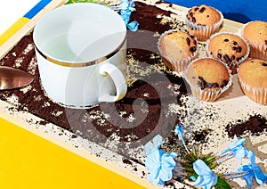 Closeup shot of cupcakes and a mug on coffee surface