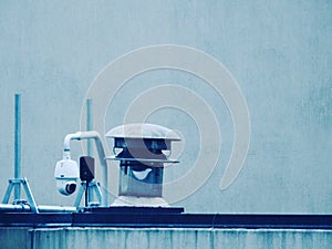 Closeup shot of cylindrical gray metal duty equipment with a light blue background