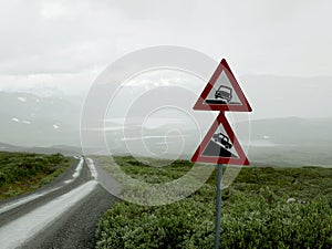 Closeup shot of dangerous roadside and steep descent road signs