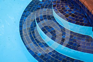 Closeup shot of dark blue mosaic steps in a pool