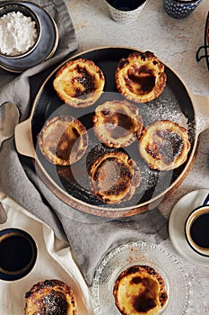 Closeup shot of delicious Pastel de Nata Vanilla pastries with espresso on a white table photo