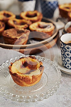 Closeup shot of delicious Pastel de Nata Vanilla pastries with espresso on a white table photo