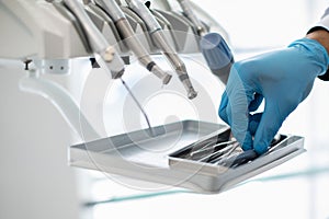 Closeup Shot Of Dentists Hand In Blue Glove Taking Sterile Stomatological Tools