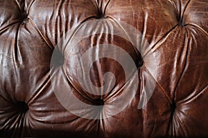 Closeup shot of the details of an old leather couch texture with worn spots, great for background