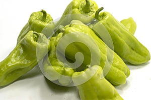 Closeup shot of digestible green peppers isolated on a white background