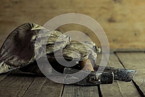 Closeup shot of dirty white gloves on a hammer and a stack of nails on the wooden ground