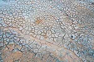 Closeup shot of dry and muddy ground with crackles and texture/pattern in geothermal area