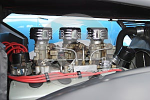 Closeup shot of an engine with a distributor and carburetors