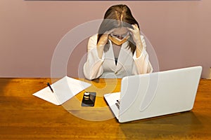Closeup shot of a female doctor at her desk in front of the laptop with tired expression