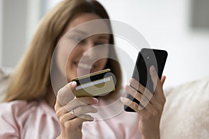 Closeup shot female hands holding credit card and smartphone