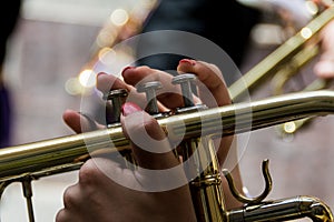 Closeup shot of female hands playing trumpet on a blurred backgroun