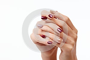 Closeup shot of a female's hands with beautiful nail polish on a white background