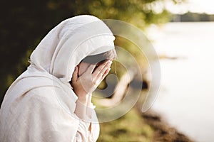 Closeup shot of a female wearing biblical robe crying  - concept confessing sins