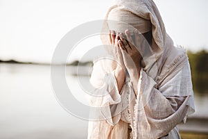 Closeup shot of a female wearing a biblical robe crying  - concept confessing sins photo