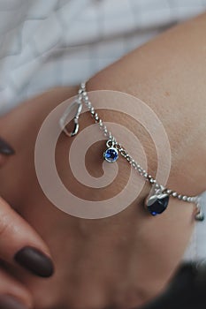 Closeup shot of a female wearing a fashionable silver charm bracelet