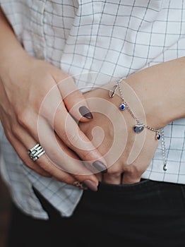 Closeup shot of a female wearing a fashionable silver charm bracelet