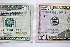 Closeup shot of a fifty and twenty-dollar bill on a white surface