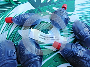 Closeup shot of fish-shaped bottles with soy sauce and a sheet of paper