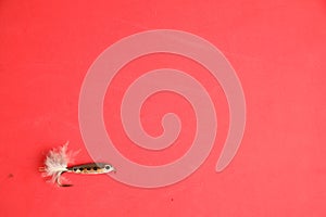 Closeup shot of fishing bait isolated on a red background