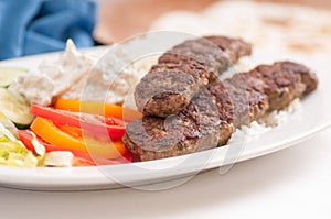 Closeup shot of flatbread wrap koobideh, iranian skewer with fresh vegetables and tzatziki sauce