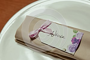Closeup shot of a floral Novia name tag on a cloth in a plate photo