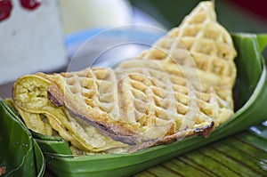 Closeup shot of a fluffy soft waffle streetfood in an eco leaf-made dish in Thailand
