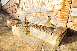 Closeup shot of a fountain on a stone wall in Canillas de Albaida in Spain photo