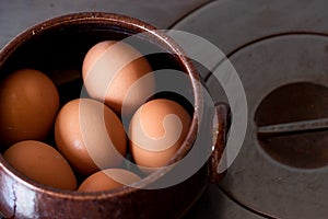 Closeup shot of fresh brown eggs in a ceramic bowl