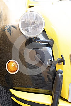 Closeup shot of the front right side headlights of a black and yellow bug car