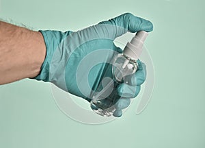 Closeup shot of a gloved hand holding a bottle of sanitizer