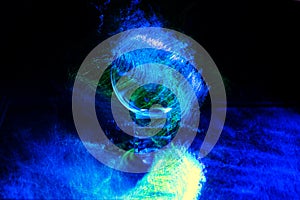 Closeup shot of a glowing crystal ball with blue and green lights on dark background