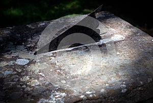 Closeup shot of a gnomon of a sundial on an old rusted metal surface