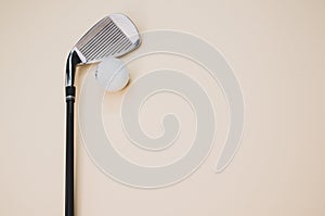 Closeup shot of a golf ball and a club  on a pink background with copyspace