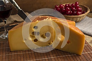 Closeup shot of a gourmet block of swiss cheese with a knife stuck inside