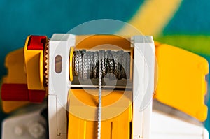 Closeup shot of gray rolled rope of a plastic toy crane