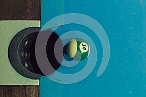 Closeup shot of green ball going in billiard pocket