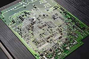 Closeup shot of green electronic circuit board PCB with components such as microchips. Technology and electronics.